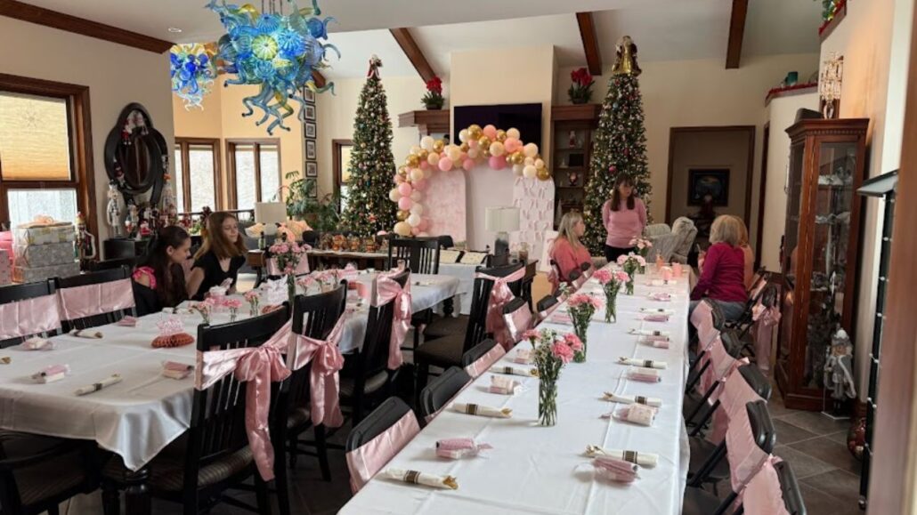 Blue hand blown glass chandelier hanging above a decorated dining space during a festive gathering